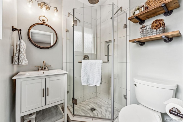 bathroom featuring vanity, an enclosed shower, and toilet