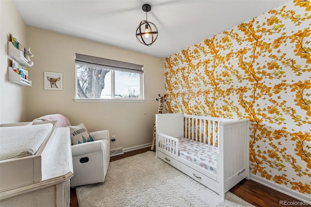 bedroom featuring a nursery area and hardwood / wood-style flooring