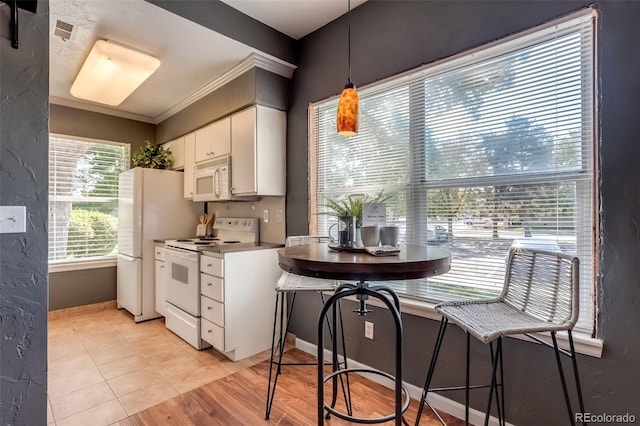 kitchen with white cabinetry, pendant lighting, white appliances, light tile patterned floors, and ornamental molding