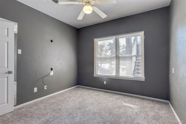 carpeted spare room with ceiling fan