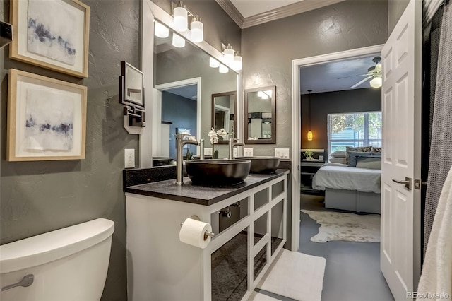 bathroom featuring toilet, ceiling fan, ornamental molding, and sink