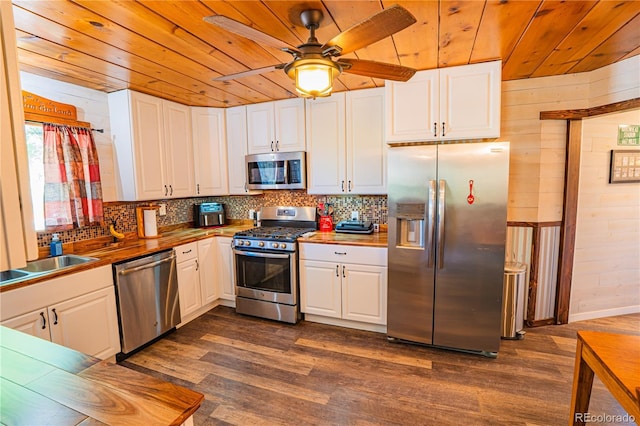 24938 US Highway 50, Cotopaxi, CO 81223 - kitchen with appliances with stainless steel finishes, wooden ceiling, dark wood-style flooring, wooden walls, and white cabinets