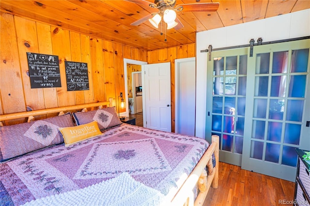 24938 US Highway 50, Cotopaxi, CO 81223 - bedroom featuring wood ceiling, a barn door, wood finished floors, and wood walls