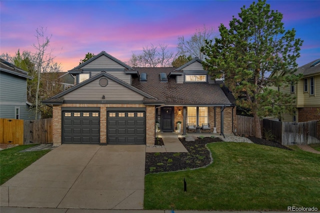 traditional home featuring a porch, fence, brick siding, driveway, and a yard