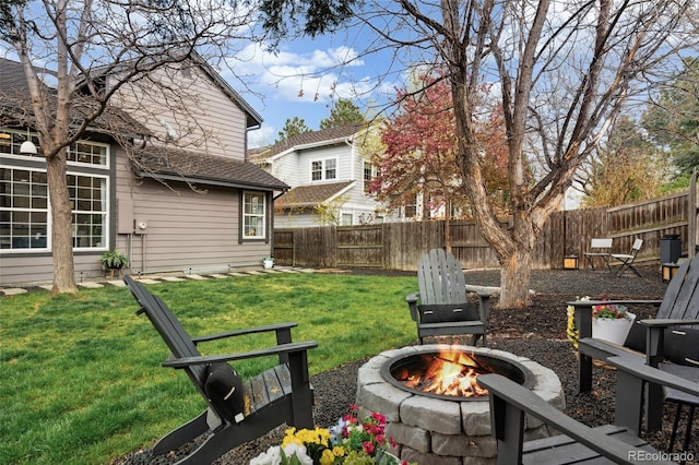 view of yard featuring a fire pit and a fenced backyard