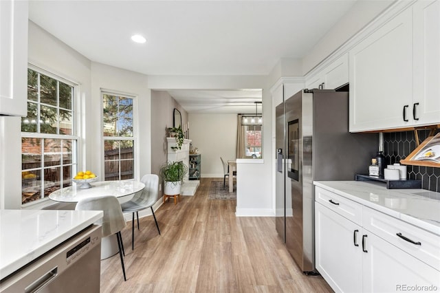 kitchen with light wood finished floors, white cabinets, and decorative backsplash