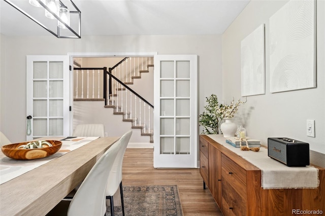 dining room with baseboards, stairway, and wood finished floors
