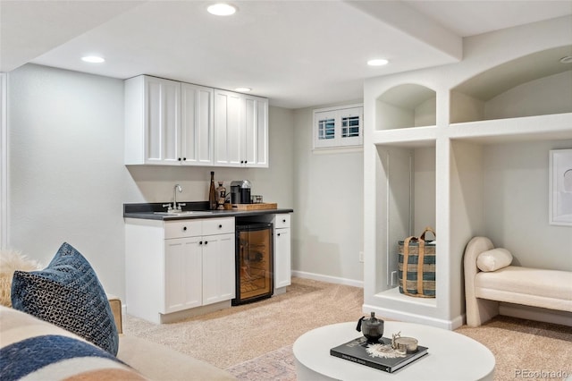 bar featuring a sink, wine cooler, wet bar, recessed lighting, and light carpet