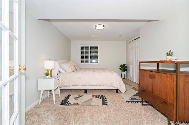 bedroom with baseboards, a closet, visible vents, and light colored carpet
