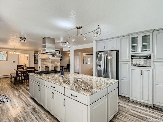 9910 Ammons Cir, Westminster, CO 80021 - kitchen featuring stainless steel fridge with ice dispenser, a chandelier, light wood finished floors, island range hood, and gas cooktop
