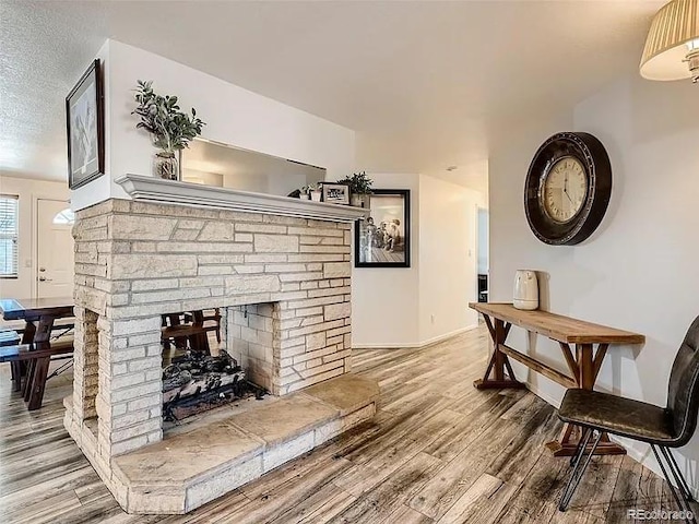 9910 Ammons Cir, Westminster, CO 80021 - living area with a fireplace, baseboards, a textured ceiling, and wood finished floors