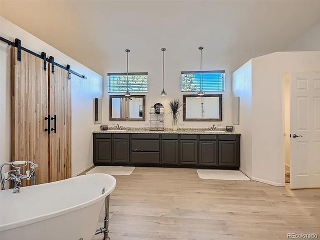 9910 Ammons Cir, Westminster, CO 80021 - bathroom with a freestanding bath, wood finished floors, double vanity, and a sink