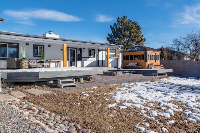 9910 Ammons Cir, Westminster, CO 80021 - snow covered rear of property with a chimney, a wooden deck, fence, and an outdoor structure