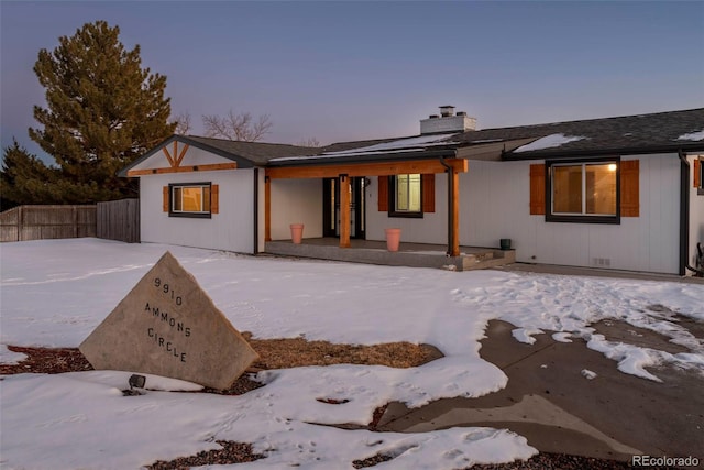 9910 Ammons Cir, Westminster, CO 80021 - snow covered property featuring a porch, fence, and a chimney