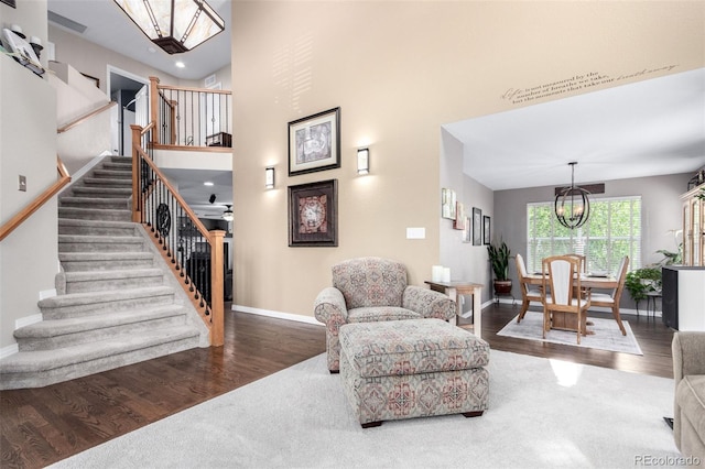 7234 S Kellerman Way, Aurora, CO 80016 - living area with stairs, a chandelier, baseboards, wood finished floors, and a towering ceiling