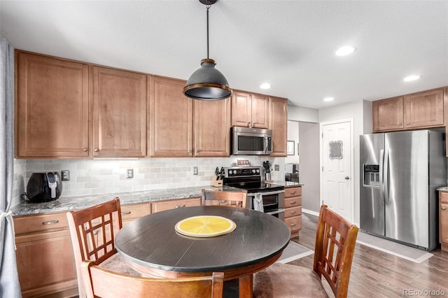 7234 S Kellerman Way, Aurora, CO 80016 - kitchen featuring appliances with stainless steel finishes, wood finished floors, backsplash, pendant lighting, and recessed lighting