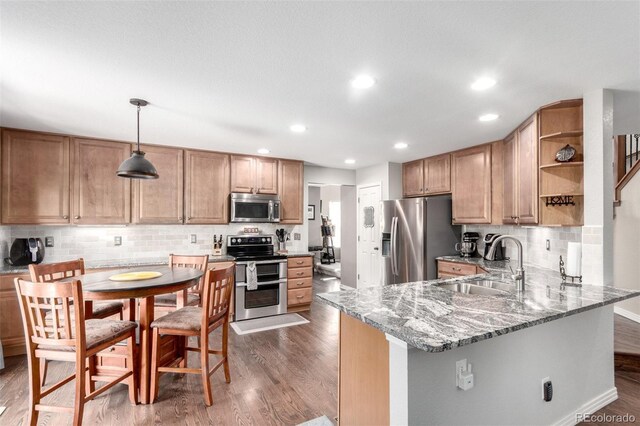 7234 S Kellerman Way, Aurora, CO 80016 - kitchen featuring appliances with stainless steel finishes, a sink, dark wood-type flooring, open shelves, and decorative backsplash
