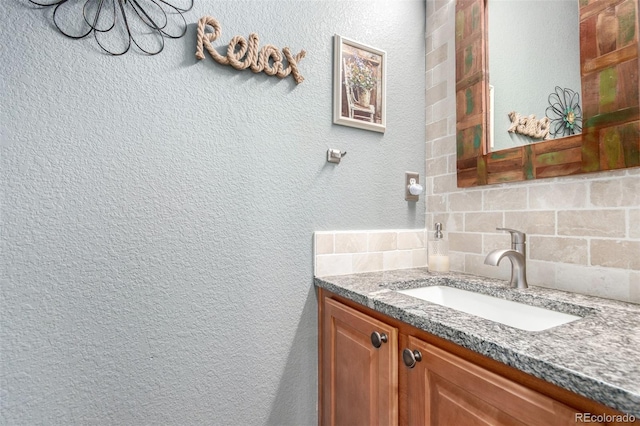 7234 S Kellerman Way, Aurora, CO 80016 - bathroom featuring decorative backsplash, vanity, and a textured wall