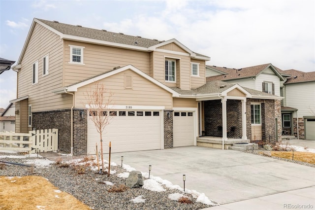 view of front of home featuring brick siding, driveway, an attached garage, and fence