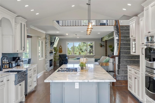 kitchen with a fireplace, a center island, stainless steel appliances, and a healthy amount of sunlight