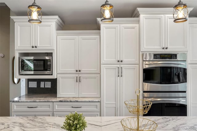 kitchen with white cabinetry, appliances with stainless steel finishes, and decorative light fixtures