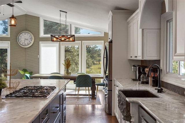 kitchen featuring vaulted ceiling, white cabinetry, dark wood-type flooring, pendant lighting, and stainless steel appliances