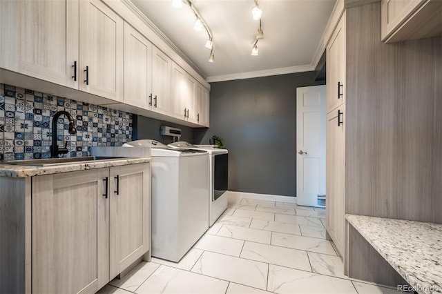 laundry area with ornamental molding, cabinets, sink, and independent washer and dryer