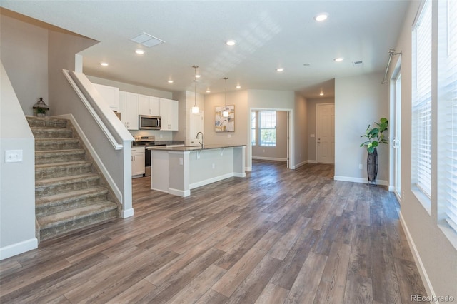 kitchen with white cabinetry, hanging light fixtures, stainless steel appliances, dark hardwood / wood-style flooring, and sink