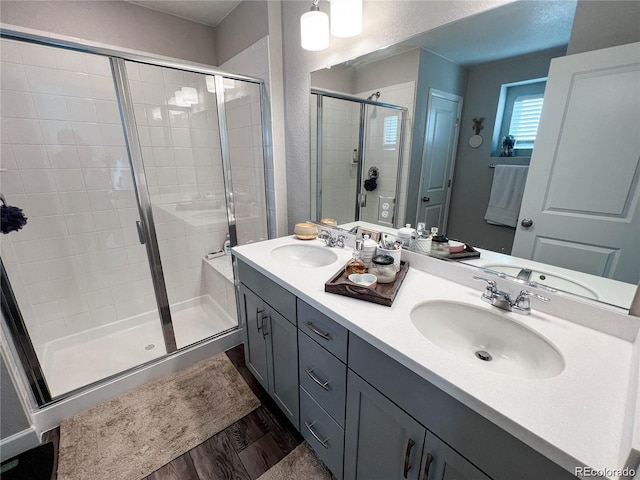 bathroom featuring wood-type flooring, an enclosed shower, and vanity