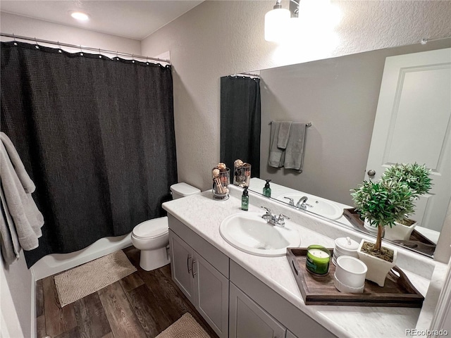 bathroom with toilet, hardwood / wood-style flooring, a shower with curtain, and vanity