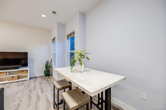 dining room featuring light wood finished floors, baseboards, visible vents, and recessed lighting