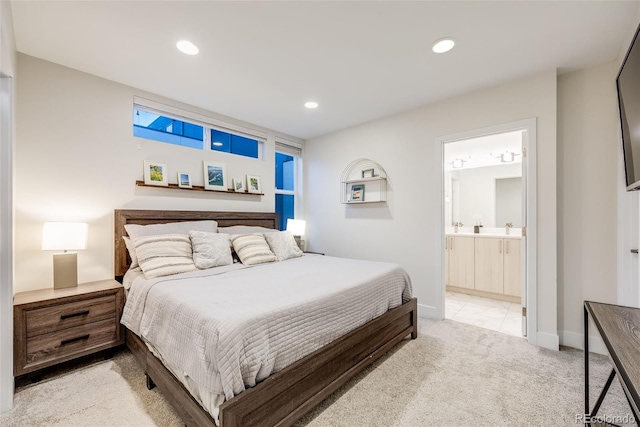 bedroom with recessed lighting, baseboards, ensuite bathroom, and light colored carpet