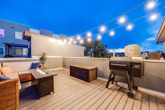 wooden terrace featuring an outdoor living space with a fire pit