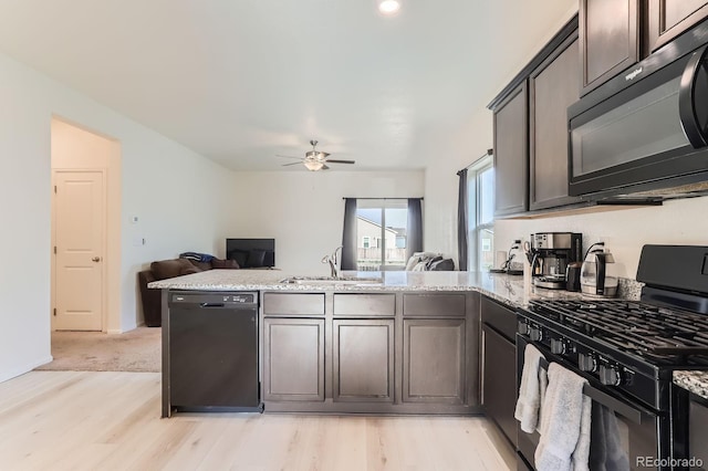 215 N Stewart St, Keenesburg, CO 80643 - kitchen with black appliances, a sink, a peninsula, open floor plan, and light stone countertops