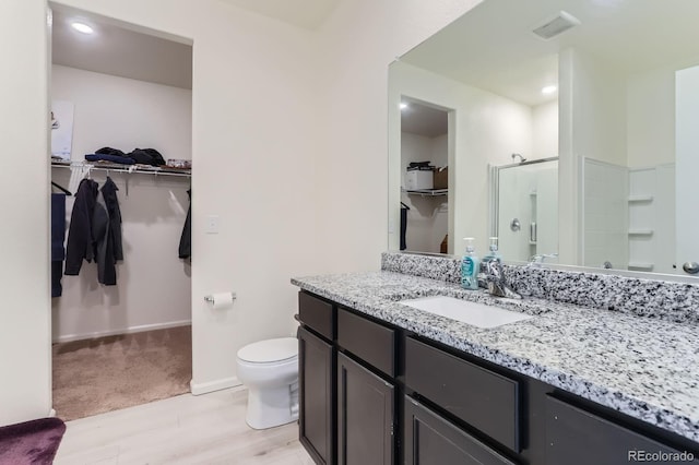 215 N Stewart St, Keenesburg, CO 80643 - full bathroom with a stall shower, toilet, wood finished floors, vanity, and baseboards