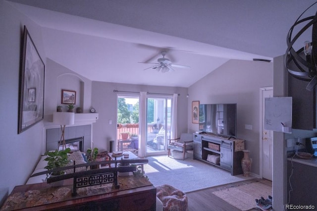 8200 E 8th Ave Unit 1203, Denver, CO 80230 - living area featuring lofted ceiling, a tiled fireplace, wood finished floors, and a ceiling fan