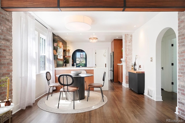 interior space with brick wall and dark hardwood / wood-style floors