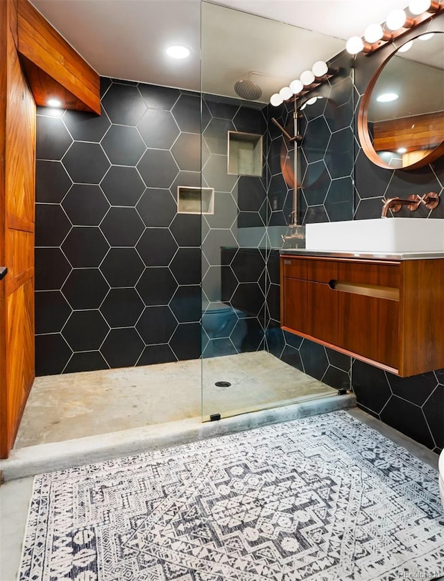 bathroom featuring tile patterned floors, vanity, and a tile shower