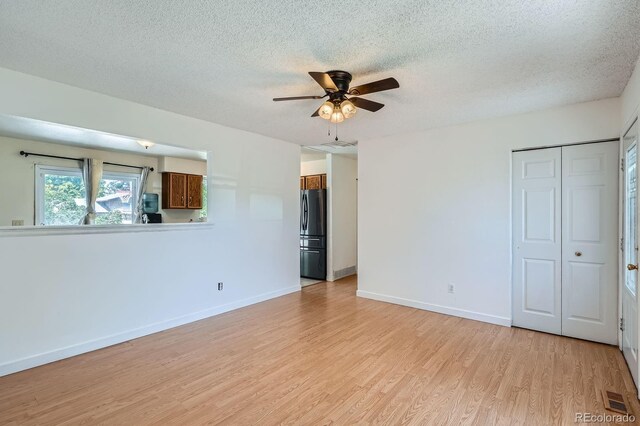 2615 S Laredo Ct, Aurora, CO 80013 - spare room with light wood-style floors, a ceiling fan, and a textured ceiling