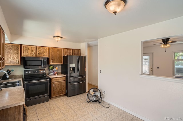 2615 S Laredo Ct, Aurora, CO 80013 - kitchen with stainless steel microwave, refrigerator with ice dispenser, black electric range oven, brown cabinets, and light countertops