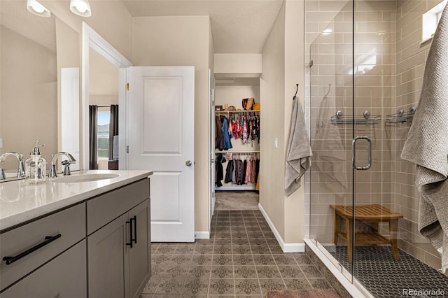 bathroom featuring a shower with door and vanity