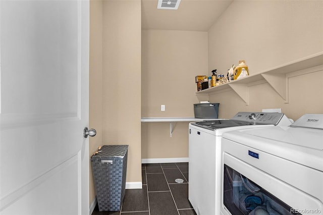 washroom with washing machine and clothes dryer and dark tile patterned floors