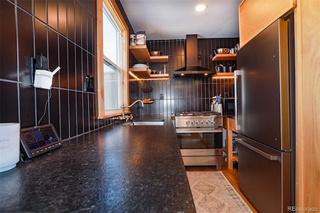 kitchen featuring tasteful backsplash, appliances with stainless steel finishes, sink, and wall chimney exhaust hood