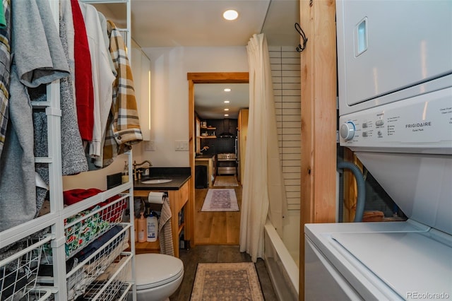 storage featuring stacked washer / drying machine and sink