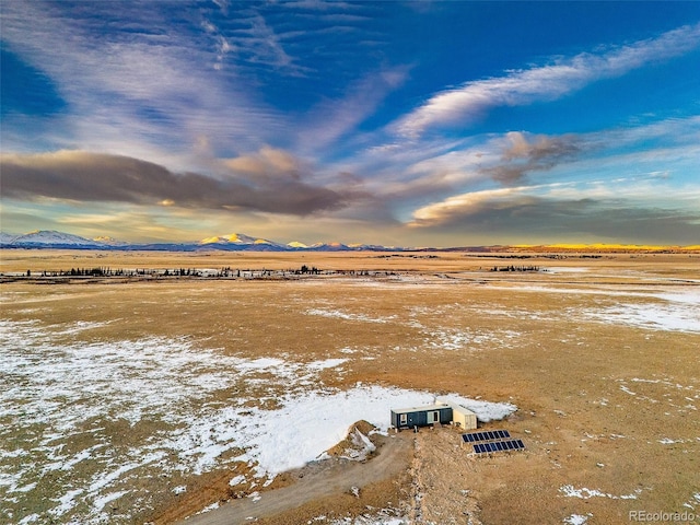 aerial view at dusk featuring a mountain view and a rural view