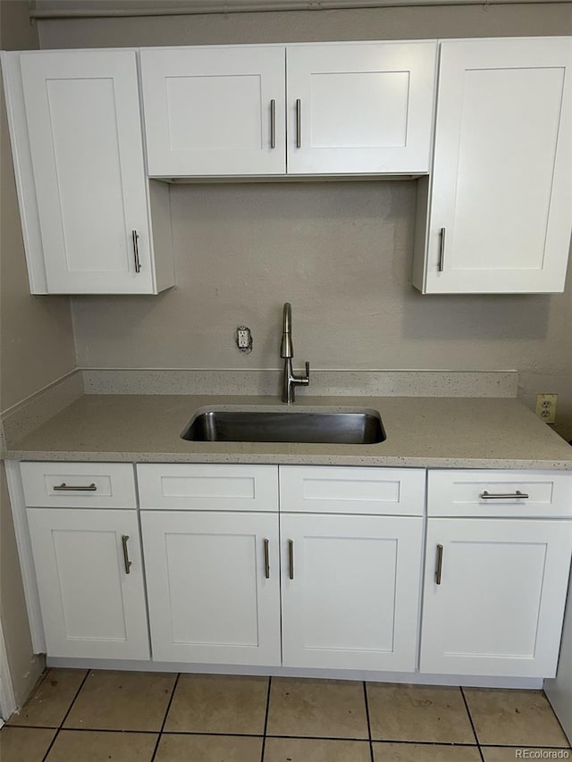 kitchen with white cabinetry, sink, and light tile patterned floors