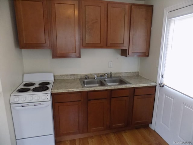 kitchen with sink, white electric range oven, and light wood-type flooring