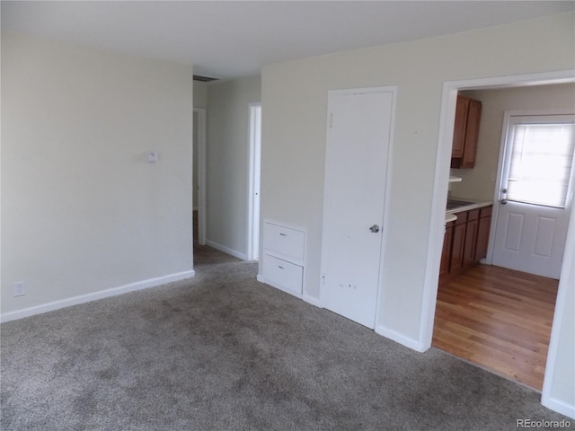 spare room with dark colored carpet