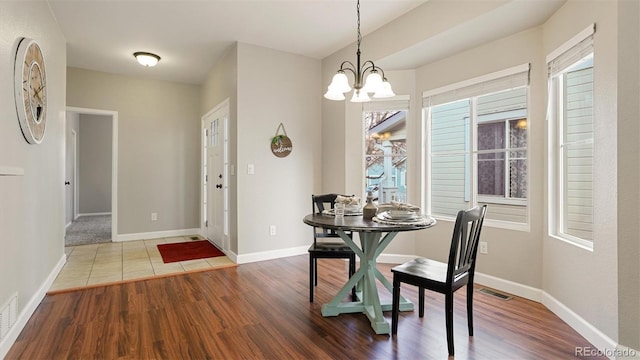 dining area with an inviting chandelier and wood-type flooring