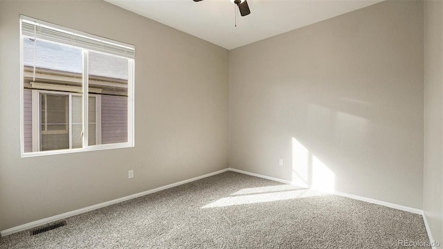 carpeted spare room with ceiling fan